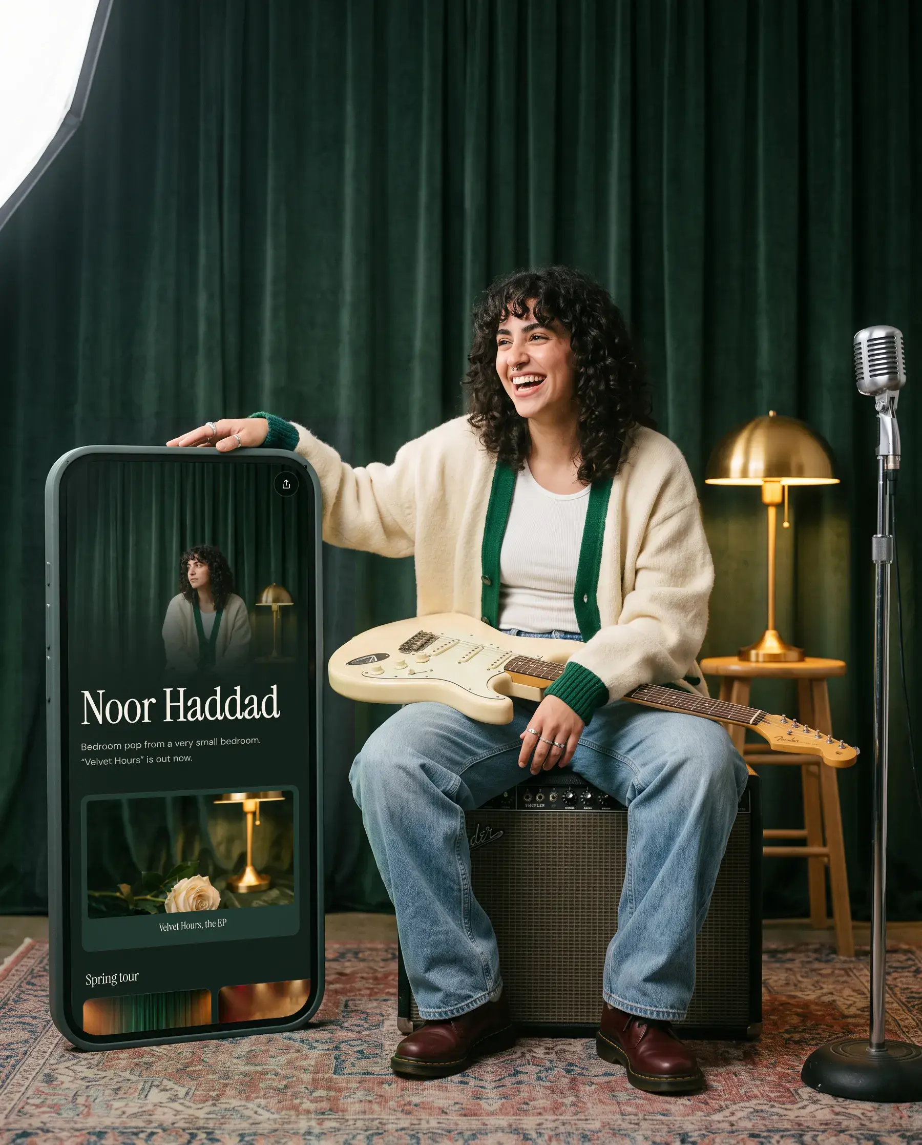 Noor Haddad, a songwriter, beside a giant phone showing her Olaa page