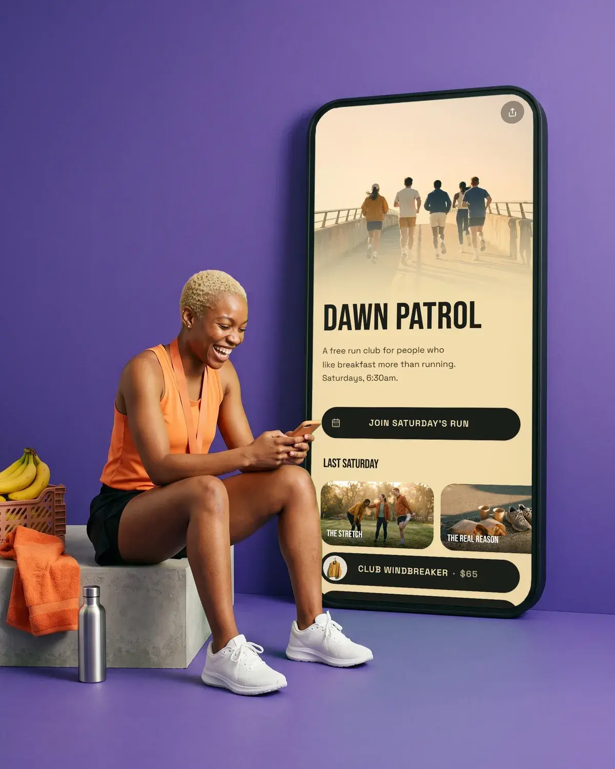 A runner checks her phone on a violet set beside a giant phone showing the Dawn Patrol page